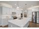 Modern kitchen featuring white cabinetry, stainless steel appliances, and a large island with bar seating at 324 Prides Xing, Rolesville, NC 27571