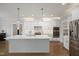 Modern kitchen featuring white cabinetry, stainless steel appliances, and a large island with bar seating at 324 Prides Xing, Rolesville, NC 27571