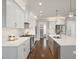 Bright, open kitchen with white cabinets, stainless steel appliances and a large central island at 324 Prides Xing, Rolesville, NC 27571