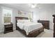 Spacious primary bedroom features a large bed, dark wood furniture and abundant natural light at 324 Prides Xing, Rolesville, NC 27571