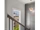 Staircase with modern railing and chandelier, illuminated by a large window at 324 Prides Xing, Rolesville, NC 27571