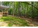 Lush backyard with manicured grass and tall trees in a private wooded setting at 3258 Yorkshire Cir, Sanford, NC 27332