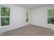 Empty bedroom with neutral carpet and large windows offering a view of the trees at 3258 Yorkshire Cir, Sanford, NC 27332