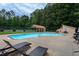 Community pool area with chairs, and a covered area, surrounded by trees at 3258 Yorkshire Cir, Sanford, NC 27332