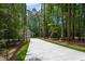 Charming home exterior with a concrete driveway surrounded by lush trees at 3258 Yorkshire Cir, Sanford, NC 27332