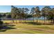 Scenic golf course with lake views and tall pine trees on a sunny day at 3258 Yorkshire Cir, Sanford, NC 27332