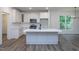 Bright kitchen with an island, stainless steel appliances, and white cabinets at 3258 Yorkshire Cir, Sanford, NC 27332