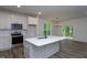 Bright kitchen features an island, white cabinets, stainless steel appliances, and modern fixtures at 3258 Yorkshire Cir, Sanford, NC 27332