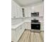 Modern kitchen showcasing white cabinets, stainless steel appliances, and stylish tile backsplash at 3258 Yorkshire Cir, Sanford, NC 27332