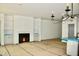 Open-concept living room featuring a fireplace, built-in shelving, and a modern light fixture at 3258 Yorkshire Cir, Sanford, NC 27332