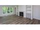 Open living room featuring a fireplace with built-in shelves, cabinets, and big windows at 3258 Yorkshire Cir, Sanford, NC 27332