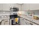 Updated kitchen features stainless steel appliances, white cabinets and subway tile backsplash, and granite countertops at 35 Stonewall Way, Durham, NC 27704
