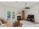 Living room with fireplace, ceiling fan, and access to the outdoor patio with nature views at 35 Stonewall Way, Durham, NC 27704