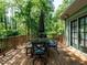 Outdoor deck with dining set and mature trees overlooking a backyard oasis at 3504 Rock Creek Dr, Raleigh, NC 27609