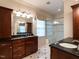 Bathroom featuring granite counters, rich wood cabinets, and glass shower enclosure at 3504 Rock Creek Dr, Raleigh, NC 27609