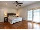 Spacious bedroom with a queen-sized bed, ceiling fan, and French doors leading to a balcony at 3504 Rock Creek Dr, Raleigh, NC 27609