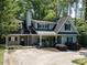 Charming light blue home with a welcoming front porch and lush landscaping at 3504 Rock Creek Dr, Raleigh, NC 27609