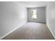 Bedroom featuring neutral carpeting, white walls, and a bright window overlooking the green lawn at 351 Gilman Ln # 109, Raleigh, NC 27610