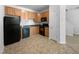 Kitchen with wooden cabinets and black appliances at 351 Gilman Ln # 109, Raleigh, NC 27610