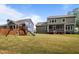 Fenced backyard with playset, well-maintained lawn, screened patio with furniture and surrounding trees at 403 Prestwood Dr, Hillsborough, NC 27278