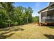 Spacious backyard featuring a large lawn, wooden playset, and surrounding mature trees at 403 Prestwood Dr, Hillsborough, NC 27278