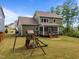 Expansive backyard with a wooden playset, grassy area, and well-maintained lawn at 403 Prestwood Dr, Hillsborough, NC 27278