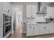 Modern kitchen featuring white cabinets, stainless steel appliances, and a view into another room at 403 Prestwood Dr, Hillsborough, NC 27278