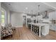 Open concept kitchen with an island bar, pendant lighting, white cabinets, and stainless-steel appliances at 403 Prestwood Dr, Hillsborough, NC 27278