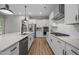 Contemporary kitchen featuring an island with a sink, stainless steel appliances, and white cabinetry at 403 Prestwood Dr, Hillsborough, NC 27278