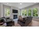 Cozy living room featuring a fireplace, large windows, and comfortable seating area at 403 Prestwood Dr, Hillsborough, NC 27278