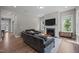 Cozy living room with fireplace and flatscreen TV, furnished with plush grey sofas and wood flooring at 403 Prestwood Dr, Hillsborough, NC 27278