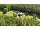 Aerial of home surrounded by green lawn, mature trees and long driveway at 407 Howard Tant Rd, Zebulon, NC 27597