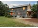 Exterior view of this log home showcasing a back porch and patio with seating, set on a sprawling lawn at 407 Howard Tant Rd, Zebulon, NC 27597