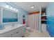 Bright bathroom with a white vanity, blue walls, and nautical-themed decorations at 407 Howard Tant Rd, Zebulon, NC 27597