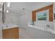 Bright bathroom featuring a soaking tub with wood paneling and a window offering natural light at 407 Howard Tant Rd, Zebulon, NC 27597