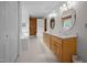 Well-lit bathroom with double sinks, wood cabinets, a soaking tub, and a separate toilet area at 407 Howard Tant Rd, Zebulon, NC 27597