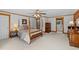 Relaxing bedroom featuring a four-poster bed, wood trim, and access to the bathroom at 407 Howard Tant Rd, Zebulon, NC 27597