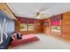 Spacious bedroom features wood walls, windows with colorful valances, ceiling fan and soft carpet at 407 Howard Tant Rd, Zebulon, NC 27597