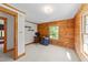 Bedroom features wood walls, carpeted floor, shelves, chair, and large window at 407 Howard Tant Rd, Zebulon, NC 27597