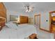 Well-lit bedroom with ceiling fan, wooden wardrobe, and adjacent bathroom at 407 Howard Tant Rd, Zebulon, NC 27597