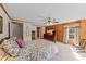 This bedroom features wood walls, a four-poster bed, and lots of natural light at 407 Howard Tant Rd, Zebulon, NC 27597