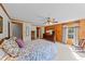 Spacious bedroom featuring wood paneled walls, four-poster bed, and soft natural lighting at 407 Howard Tant Rd, Zebulon, NC 27597