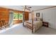 Charming bedroom featuring natural wood walls, a four poster bed, and a ceiling fan at 407 Howard Tant Rd, Zebulon, NC 27597