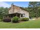 Quaint log home with a covered porch, stone chimney, and well-maintained landscaping at 407 Howard Tant Rd, Zebulon, NC 27597