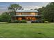 Charming log cabin with a welcoming front porch, lush lawn and mature landscaping at 407 Howard Tant Rd, Zebulon, NC 27597