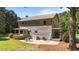 Rear exterior with cozy patio, landscaped yard, and a rustic two-story design at 407 Howard Tant Rd, Zebulon, NC 27597