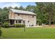 Rustic log cabin showcasing a large backyard, stone chimney, metal roof, and a cozy patio area at 407 Howard Tant Rd, Zebulon, NC 27597