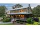 Charming log cabin with stone chimney and inviting wrap-around porch at 407 Howard Tant Rd, Zebulon, NC 27597