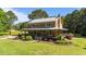 Beautiful log home with a covered porch and picturesque landscaping at 407 Howard Tant Rd, Zebulon, NC 27597
