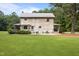 View of a charming log cabin with green grass, a patio, and mature landscaping at 407 Howard Tant Rd, Zebulon, NC 27597
